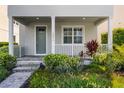 Charming front porch with gray pavers and lush, tropical landscaping at 5711 Hamlin Groves Trl, Winter Garden, FL 34787