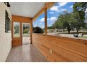 Inviting front porch featuring wood paneling, tiled floor, and bright, natural light at 6366 Sw 115Th Street Rd, Ocala, FL 34476