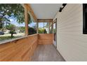 Inviting front porch featuring wood paneling, tiled floor, and bright, natural light at 6366 Sw 115Th Street Rd, Ocala, FL 34476