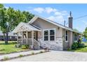 Quaint single-story home boasting stone veneer accents, a manicured lawn, and a charming covered porch at 720 N 6Th St, Haines City, FL 33844