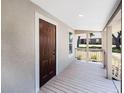 Covered porch showing the front door entrance and providing a shaded outdoor seating area with an open view at 720 N 6Th St, Haines City, FL 33844