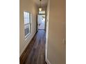 Entry hallway with dark laminate floors, neutral paint, and natural light at 7314 Seena Ct, Orlando, FL 32835