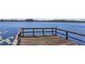 Wooden dock extending over calm blue waters, perfect for lakeside relaxation and recreation at 9222 Charles E Limpus Rd, Orlando, FL 32836
