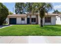 Attractive single-story house with a lush lawn and a mature palm tree in the front yard at 10665 Whitman Cir, Orlando, FL 32821