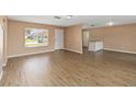 Spacious living room featuring modern wood floors and plenty of natural light from a large window at 10665 Whitman Cir, Orlando, FL 32821