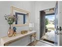 Bright entryway featuring a decorative mirror, accent table, and view to front door at 15532 Kensington Trl, Clermont, FL 34711