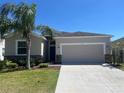 Charming single-Gathering home featuring a well-manicured lawn and a two-car garage at 1711 Penrith Loop, Orlando, FL 32824