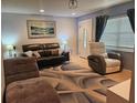 Cozy living room featuring a plush rug, comfortable seating, and a modern art piece on the wall at 1720 Hope Dr, Ormond Beach, FL 32174