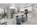 Modern kitchen with white cabinets, a center island with seating, and stainless steel appliances at 197 Flame Ave, Maitland, FL 32751