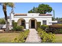 Inviting home displaying tidy landscaping, a brick pathway, and an attractive arched entryway at 2107 Delaney Ave, Orlando, FL 32806