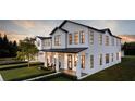 Elegant two-story home featuring a modern design, sleek black windows, and manicured lawn at 22 W Hazel St, Orlando, FL 32804