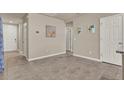 Spacious hallway with tile flooring, neutral walls, and white doors leading to various rooms at 30276 Armenia Rd, Leesburg, FL 34748