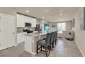 Modern kitchen with granite countertops, white cabinets, stainless steel appliances, and island with seating at 30276 Armenia Rd, Leesburg, FL 34748