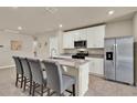 Modern kitchen with granite countertops, white cabinets, stainless steel appliances, and a kitchen island with seating at 30276 Armenia Rd, Leesburg, FL 34748
