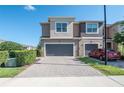 Charming townhome with a two-car garage and brick-paved driveway, complemented by lush greenery at 335 Merry Brook Cir, Sanford, FL 32771