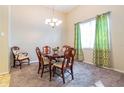 Formal dining area featuring a chandelier, a large window, and stylish decor at 3509 Battersea Ct, Belle Isle, FL 32812