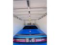 Garage showcasing a shiny blue car, bright lighting, and a clean, organized space for vehicle storage at 3623 Main Harbor Dr, Kissimmee, FL 34746