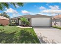 Inviting single-Gathering home with lush green lawn, large driveway, and beautiful landscaping at 4008 Lakeside Reserve Ct, Orlando, FL 32810