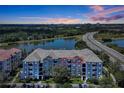 Condominium exterior showcasing multiple floors with balconies and sunset views, near a highway and lake at 4126 Breakview Dr # 40901, Orlando, FL 32819