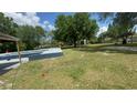 Large backyard with a pool, well maintained grass, and gazebo in the far corner at 434 Diamond Acres Rd, Davenport, FL 33837