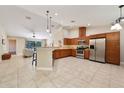Open kitchen features stainless steel appliances, wood cabinets, and a breakfast bar overlooking the living area at 510 N Leavitt Ave, Orange City, FL 32763
