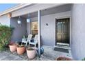 Inviting front porch with seating, potted plants, and decorative hanging planters at 525 E Foothill Way, Casselberry, FL 32707