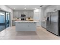 Modern kitchen with stainless steel appliances, gray cabinets, and large island at 543 Pine Tree Bridge Trl, St Cloud, FL 34772