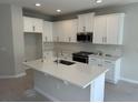 Bright kitchen featuring white cabinets, stainless steel appliances, kitchen island, and tile backsplash at 620 Pothos St, Apopka, FL 32703