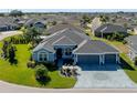 Expansive aerial shot of a single-story home with a three-car garage in a quiet neighborhood at 6328 Merhottein Loop, The Villages, FL 32163