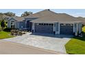 Well maintained single story home featuring a three car garage and decorative concrete driveway at 6328 Merhottein Loop, The Villages, FL 32163