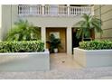 Exterior view of a private entrance framed with verdant plants and hedges at 8761 The Esplanade # 6, Orlando, FL 32836