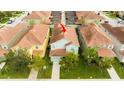 Aerial view of a two-story townhome with a terracotta-colored roof and well-manicured lawn at 9004 Majesty Palm Rd, Kissimmee, FL 34747