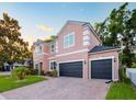 Charming two-story home with a three-car garage and brick driveway and manicured lawn at 925 Counts Crest Cir, Apopka, FL 32712
