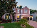 Beautiful two-story home with a three-car garage, manicured lawn, and landscape lighting at 925 Counts Crest Cir, Apopka, FL 32712