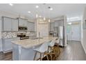 Modern kitchen boasts stainless steel appliances, granite countertops, and a large center island at 9456 Komika Ln, Winter Garden, FL 34787