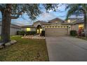 Charming single-story home with a spacious two-car garage, well-manicured lawn, and beautiful landscaping at dusk at 9736 Heron Pointe Dr, Orlando, FL 32832