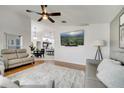 Bright living room with hardwood floors, neutral-toned furniture, and an adjacent open-concept kitchen at 9736 Heron Pointe Dr, Orlando, FL 32832