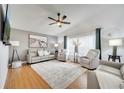 Bright living room with hardwood floors, a ceiling fan, and comfortable neutral-toned furniture at 9736 Heron Pointe Dr, Orlando, FL 32832