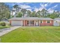 Charming single story red brick home with a well-manicured lawn and attached garage at 976 W Gaucho Cir, Deltona, FL 32725