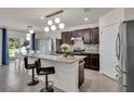 Stunning kitchen featuring stainless steel appliances, dark wood cabinets, and an island with bar seating at 1068 Brooklet Dr, Davenport, FL 33837