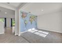 Bright living room features a world map accent wall, and new carpet at 1068 Brooklet Dr, Davenport, FL 33837