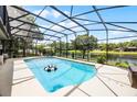 Enclosed pool area with a large pool, lounge chairs, and lush landscaping at 107 Coveridge Ln, Longwood, FL 32779