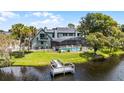 Backyard view features a screened pool, fenced yard, lush greenery, and a private dock at 107 Coveridge Ln, Longwood, FL 32779