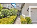 Inviting front entrance with lush landscaping, paver walkway, and charming front door at 1090 Wildmeadow Run, Winter Park, FL 32792