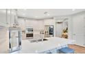 Modern kitchen featuring white cabinets, stainless steel appliances, and a large center island at 1090 Wildmeadow Run, Winter Park, FL 32792