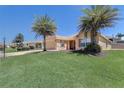 Inviting single-story home with mature palm trees and a beautifully landscaped yard at 12711 Se 97Th Terrace Rd, Summerfield, FL 34491