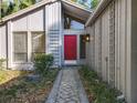 Charming home featuring a striking red front door, a stone pathway, and a distinctive exterior architecture at 136 Bridgeview Ct, Longwood, FL 32779