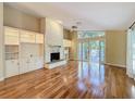 Bright living room featuring a stone fireplace, hardwood floors, and large windows offering natural light at 136 Bridgeview Ct, Longwood, FL 32779