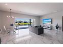 Open-concept living room boasting marble floors, modern lighting, and sliding glass doors with a water view at 13828 Tybee Beach Ln, Orlando, FL 32827
