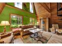 Living room with striking green accent wall, wood paneling, and natural light from large windows at 14143 Conifer Dr, Orlando, FL 32832